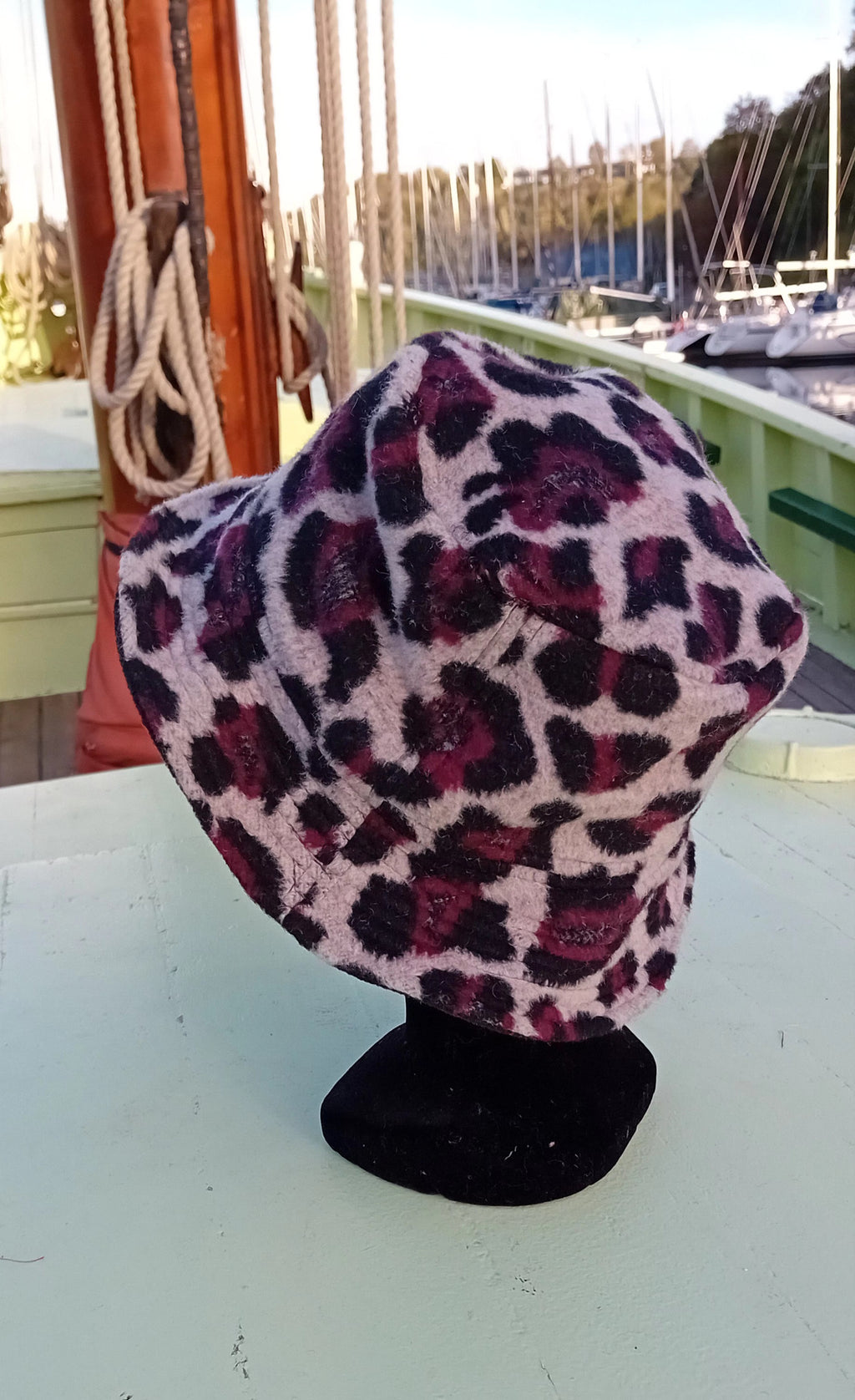 Affirmez votre style avec ce bob tendance motif léopard aux nuances prunes, noires et écrues. Confectionné à la main en France dans une matière effet mailles/fausse fourrure douillette, ce chapeau allie confort thermique et élégance sauvage.